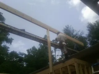 Carpenter setting a ridge beam over a new addition frame — Ice Dam Removal by Roofing Brothers in Kings Mountain
