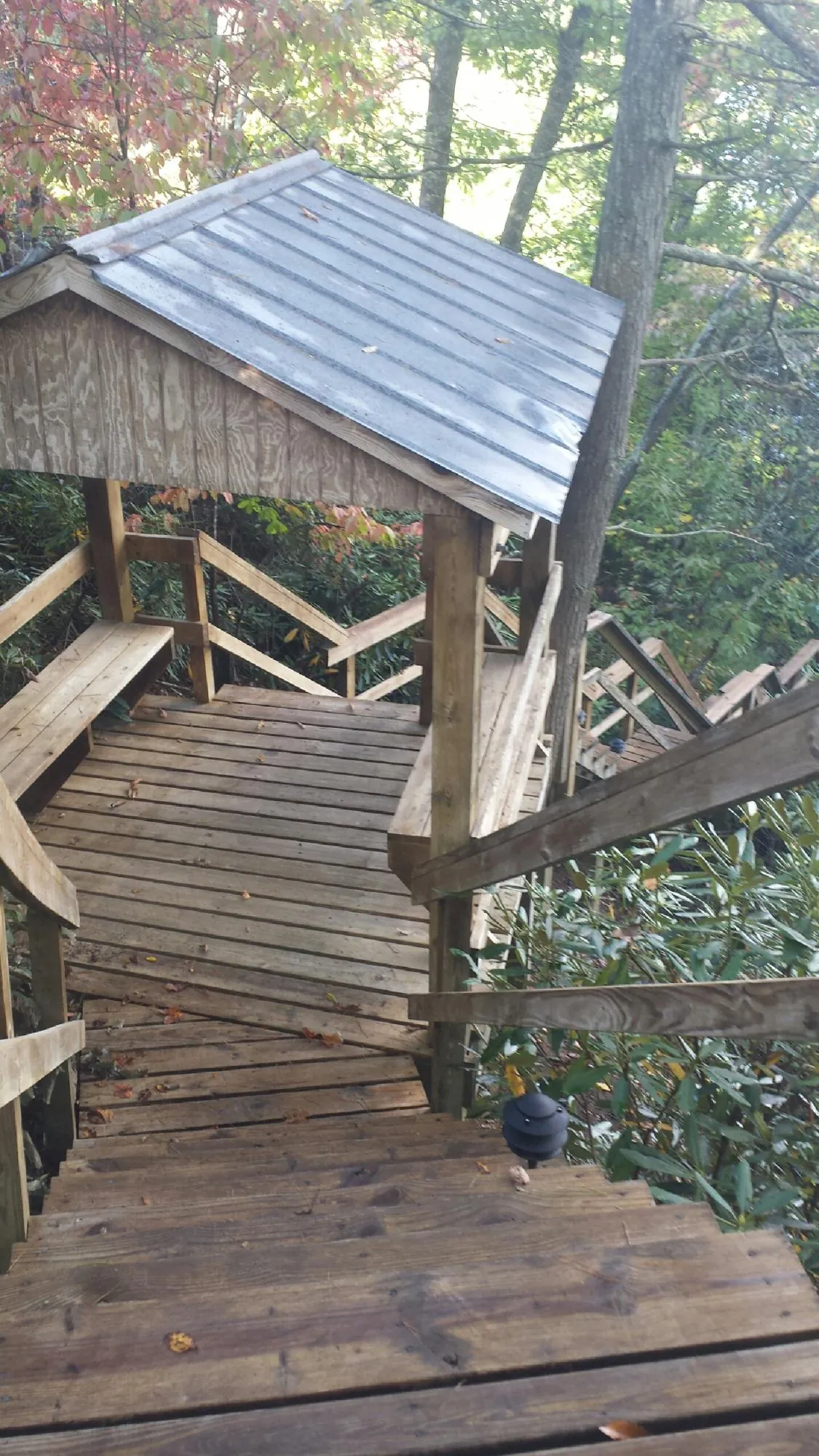 Metal roofed shelter over wooden steps on a wooded walkway — Skylight Repair & Installation work by our crew in Kings Mountain